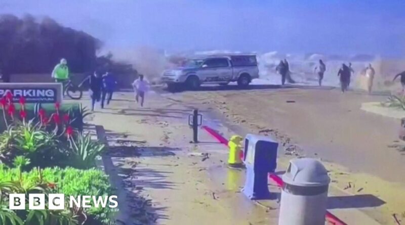 Beachgoers swept away as huge wave crashes over wall