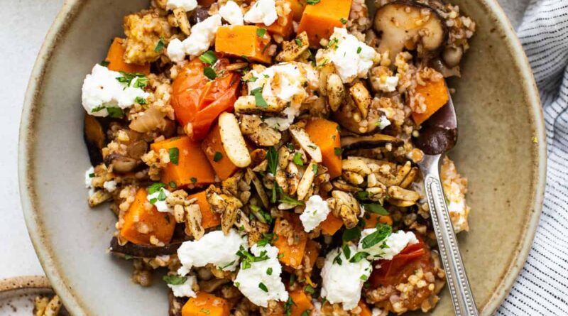 A bowl of quinoa and squash with feta and nuts.