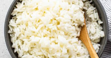 White rice in a bowl with a wooden spoon.