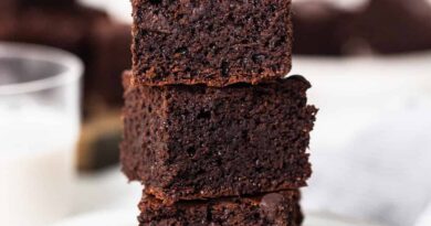 A stack of chocolate brownies on a plate.