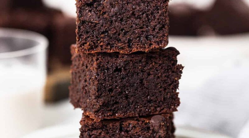 A stack of chocolate brownies on a plate.