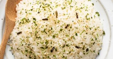 Japanese rice on a white plate with a wooden spoon.