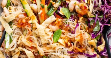 A bowl of asian noodle salad with shrimp and vegetables.