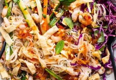 A bowl of asian noodle salad with shrimp and vegetables.