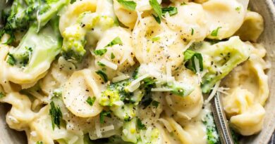 A bowl of pasta with broccoli and parmesan cheese.