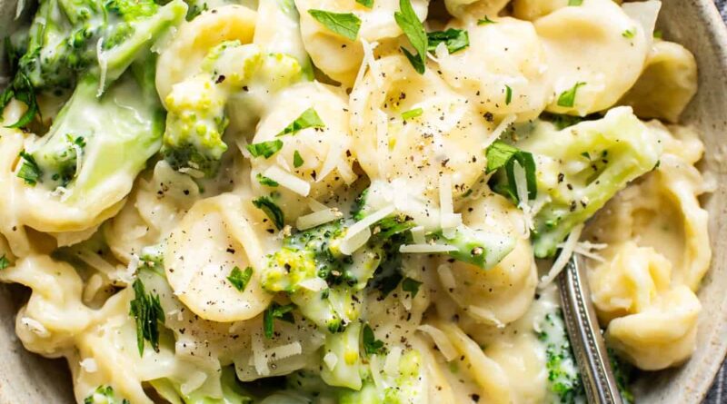 A bowl of pasta with broccoli and parmesan cheese.