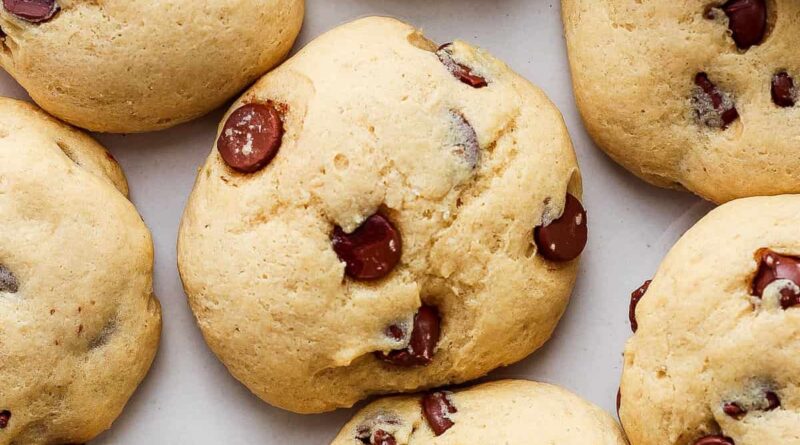 A group of chocolate chip cookies on a white surface.