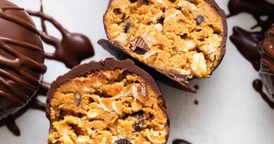 Chocolate covered peanut butter truffles on a white surface.