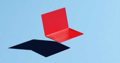 Conceptual image of a red laptop floating mid-air on a blue background with a hard shadow