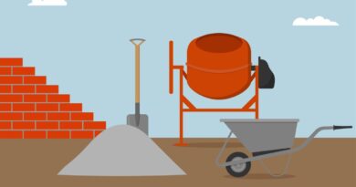 Brick wall, concrete mixer, wheelbarrow, bucket and spade.