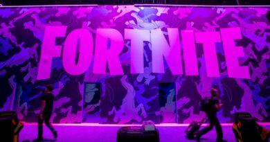 Attendees walk past signage for Epic Games Inc.'s Fortnite