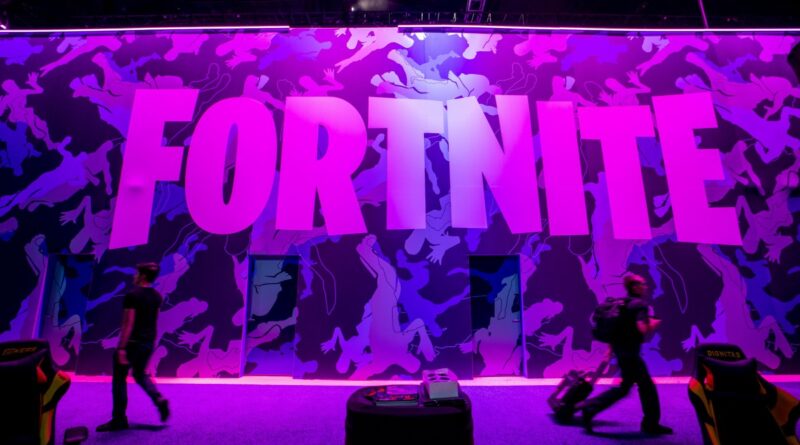 Attendees walk past signage for Epic Games Inc.'s Fortnite