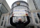 A protester holds a sign that reads, "Garcia Luna is guilty"