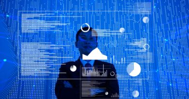 Man standing in front of big blue screen with charts and data spread out before him.