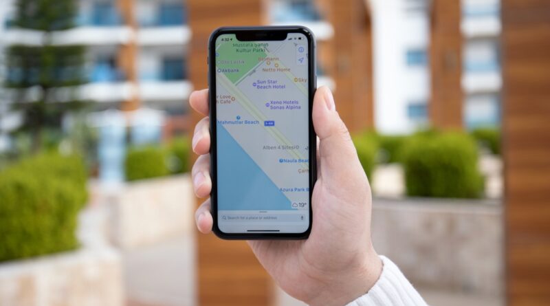 Man hand holding iPhone 11 with Apple map on screen