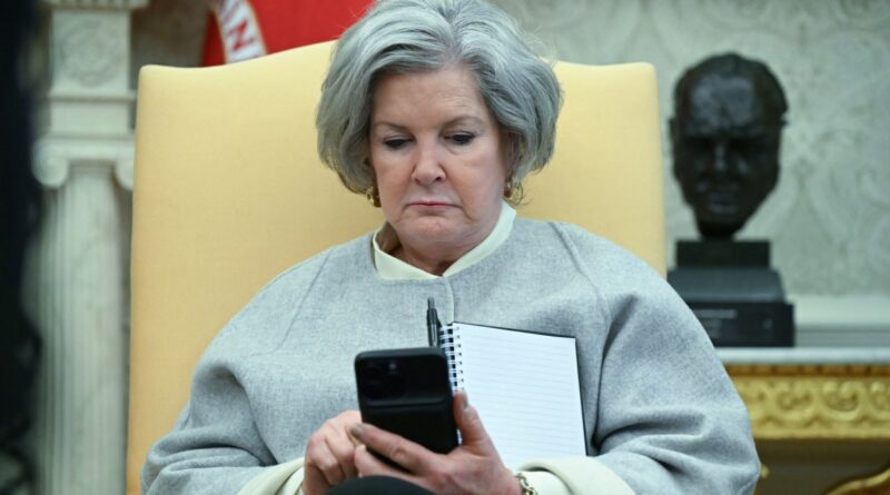 White House chief of staff Susie Wiles looks at her phone as US President Donald Trump speaks in the Oval Office of the White House