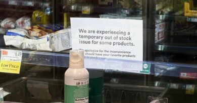 a photo of the frozen and refrigerated section at a local Whole Foods, with empty spaces, and signs warning of an out-of-stock issue.