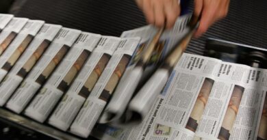 A photo of a stream of newspapers on the printing press.