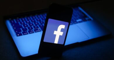 Facebook logo displayed on a phone screen and a laptop are seen in this illustration photo