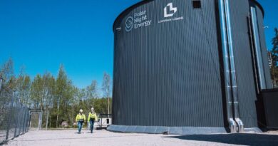 Two technicians walk by the Pornainen sand battery.
