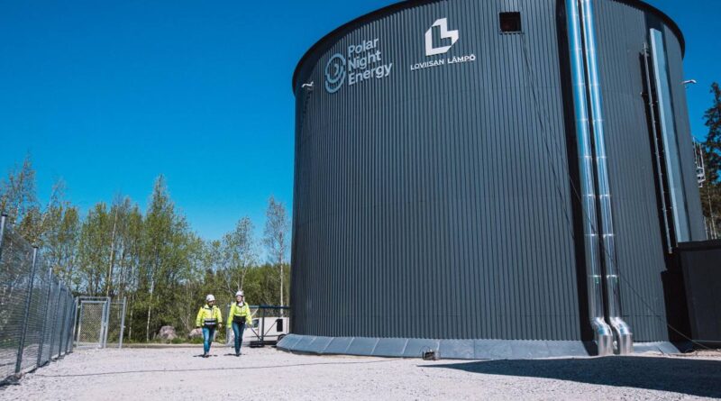 Two technicians walk by the Pornainen sand battery.
