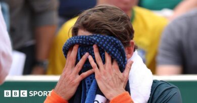 Alex de Minaur covers his face with a towel at the French Open