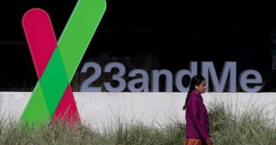 A pedestrian walks by a sign posted in front of the 23andMe headquarters in Sunnyvale, California. (Image: Justin Sullivan/Getty Images)