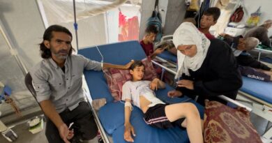 Ihab and Iman Musleh hover near their son's hospital bed in a makeshift tent ward