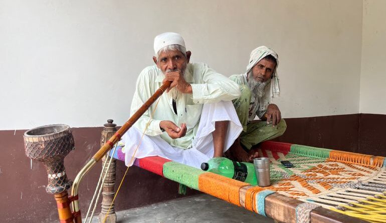 Mohammad Noor sitting with his childhood friend, Tajamul Mohammad, at his home in Uttawar, Haryana. [Yashraj Sharma/Al Jazeera]