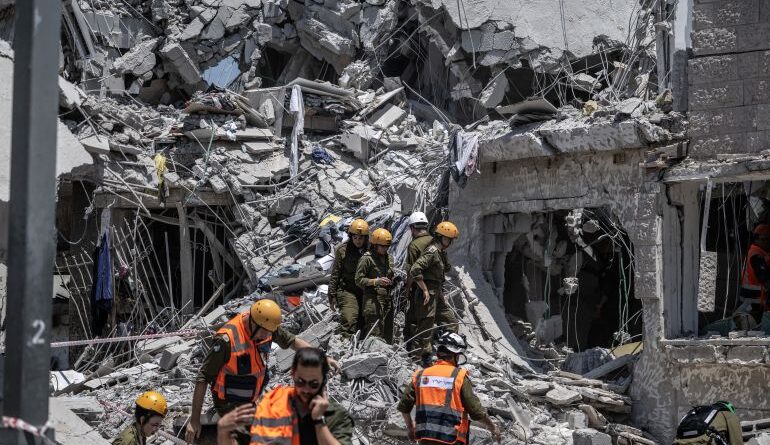 Israeli search and rescue team conduct operation amid the rubble of destroyed building after the attacks of Iranian army following the launch of large-scale Israeli strikes against Iran in Rishon LeZion, Israel on June 14, 2025. [Mostafa Alkharouf/Anadolu Agency]