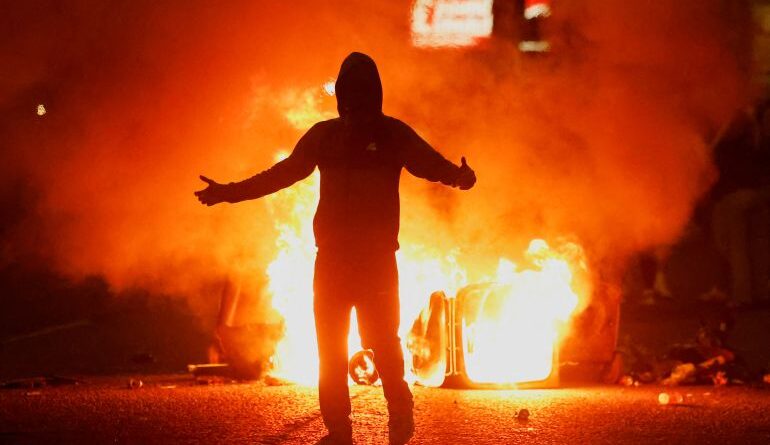 Fire burns near a demonstrator as riots continue in Ballymena, Northern Ireland, June 11, 2025. REUTERS/Clodagh Kilcoyne TPX IMAGES OF THE DAY