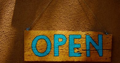 A wooden, hand-painted "Open" sign