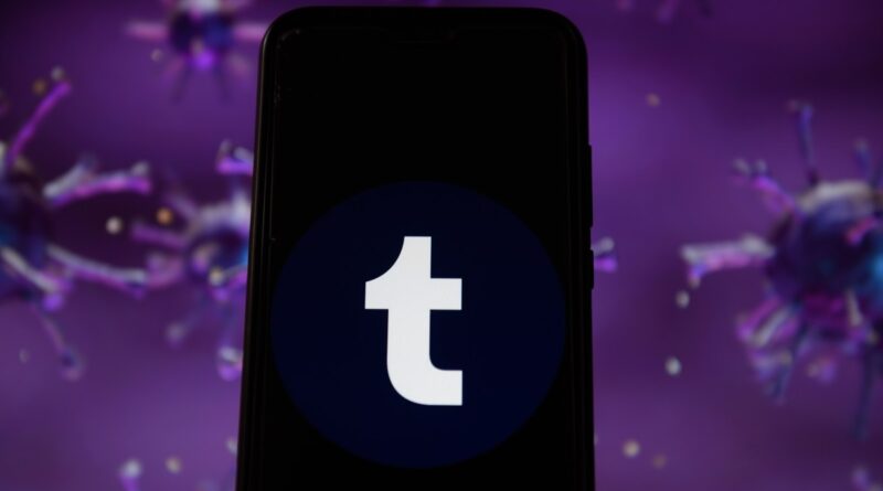 Photo illustration of a Tumblr logo displayed on a smartphone with a COVID 19 sample image in the background.