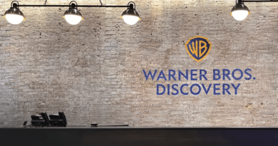 Warner Bros. Discovery logo on a brick wall