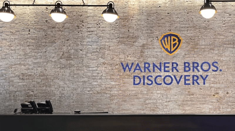 Warner Bros. Discovery logo on a brick wall