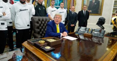 Donald Trump sits at the Resolute Desk, with members of the Juventus soccer team behind him.