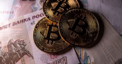 Novelty Bitcoin tokens are photographed besides Russian rouble bank notes.