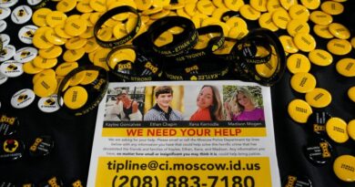 FILE - A flyer seeking information about the killings of four University of Idaho students who were found dead is displayed on a table along with buttons and bracelets on Nov. 30, 2022, during a vigil in memory of the victims in Moscow, Idaho. Attorneys for Bryan Kohberger, the man charged with stabbing four University of Idaho students to death, are expected to ask a judge to move the trial away from the rural college town where the killings occurred. (AP Photo/Ted S. Warren, File)
