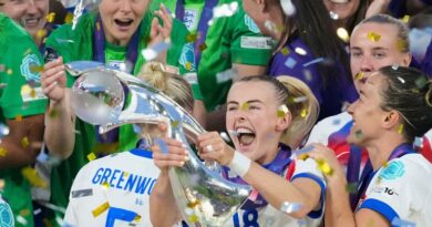 England's Chloe Kelly celebrates with the trophy as goalkeeper Hannah Hampton at left looks on after winning the Women's Euro 2025 final soccer match between England and Spain at St. Jakob-Park in Basel, Switzerland, Sunday, July 27, 2025. (AP Photo/Alessandra Tarantino)