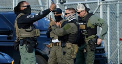 Immigration and Customs Enforcement (ICE) agents use their phones near protestors at a demonstration in Elizabeth, New Jersey May 7, 2025, outside Delaney Hall, a newly converted immigrant detention centre.