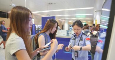 A border police officer answers questions from inbound passengers at Chongqing Jiangbei International Airport in southwest China's Chongqing, July 8, 2025.