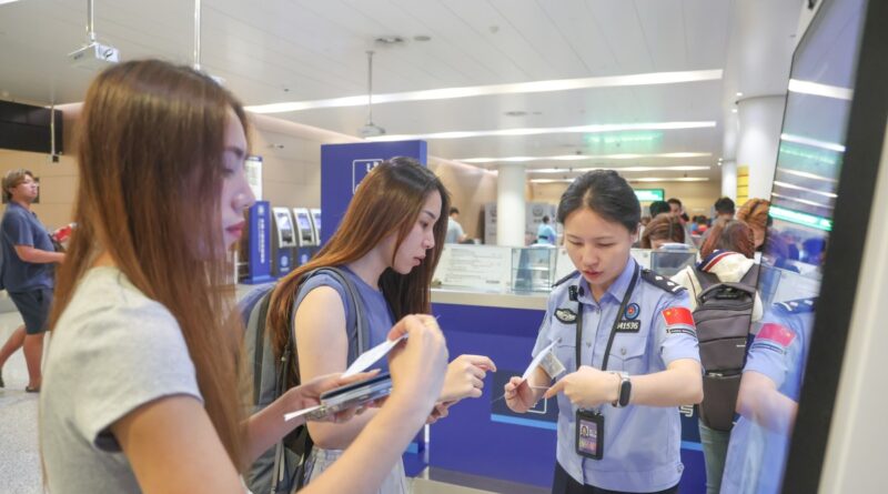A border police officer answers questions from inbound passengers at Chongqing Jiangbei International Airport in southwest China's Chongqing, July 8, 2025.