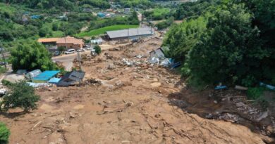 a view of a flooded village with torrents of brown water