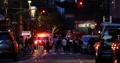 Federal agents, center, and NYPD officers close off East 50th Street between Madison and Park Avenues
