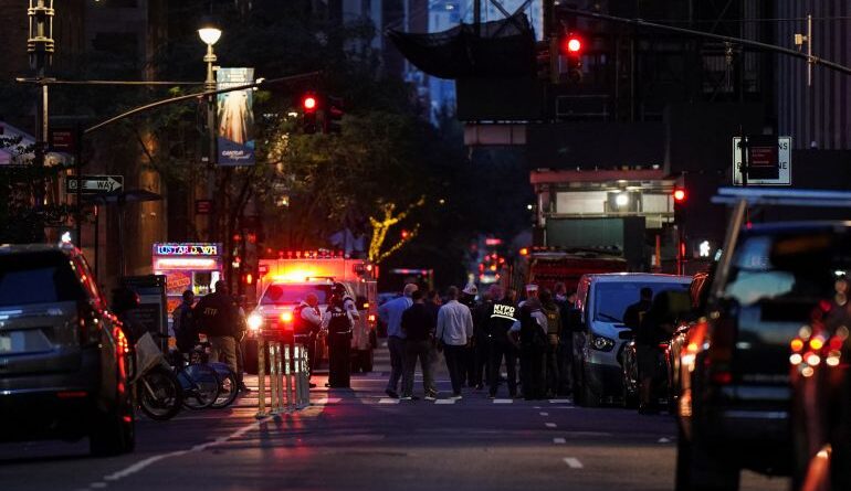 Federal agents, center, and NYPD officers close off East 50th Street between Madison and Park Avenues