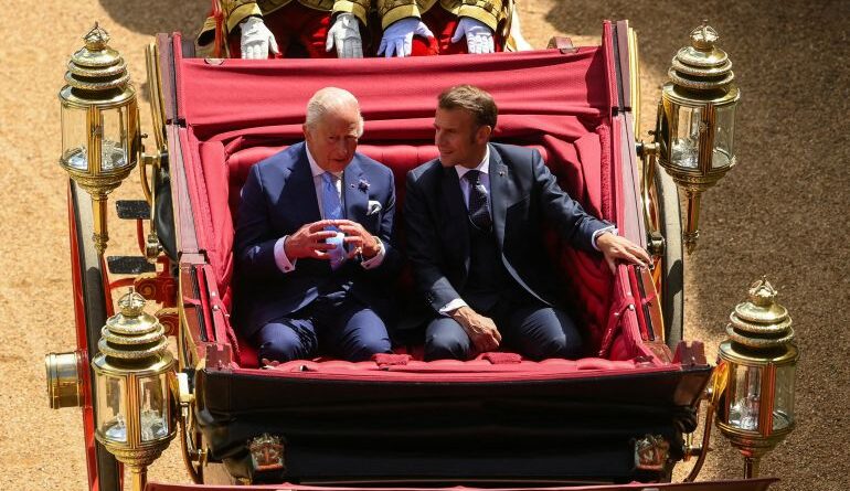 Britain's King Charles and French President Emmanuel Macron sit on a carriage as they arrive at Windsor Castle, in Windsor, Britain, July 8, 2025.