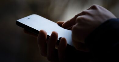 A photo of a person's phone in someone's hand, the image is darkened.