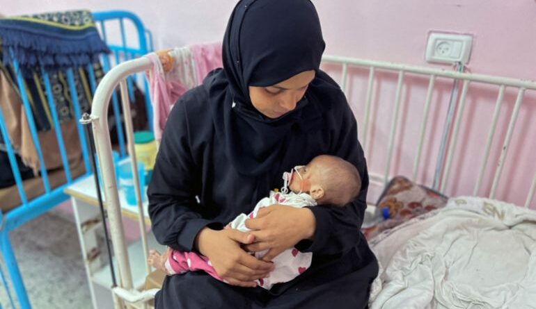 Palestinian mother Israa Abu Haleeb looks after her five-month-old daughter, Zainab, who is diagnosed with malnutrition, according to medics, at Nasser hospital in Khan Younis [File: Hussam Al-Masri/Reuters]