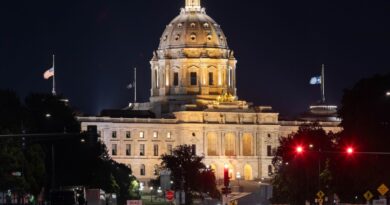 A scenic view of the majestic Minnesota State Capitol building in St. Paul, dramatically illuminated against the night sky