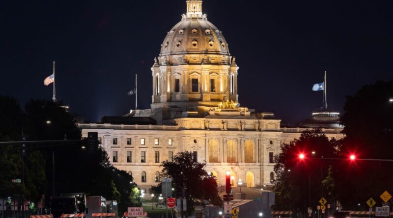 A scenic view of the majestic Minnesota State Capitol building in St. Paul, dramatically illuminated against the night sky